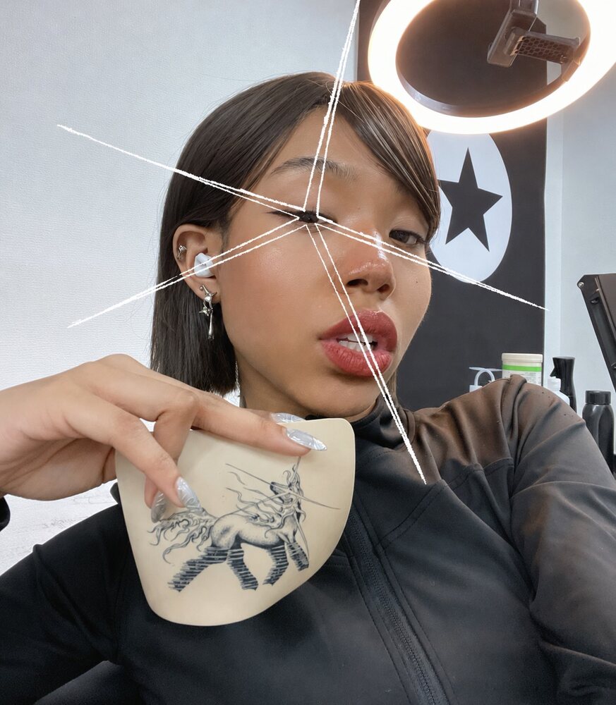 Otani, tattoo artist at Third Eye Studio, holding one of her ornamental designs
